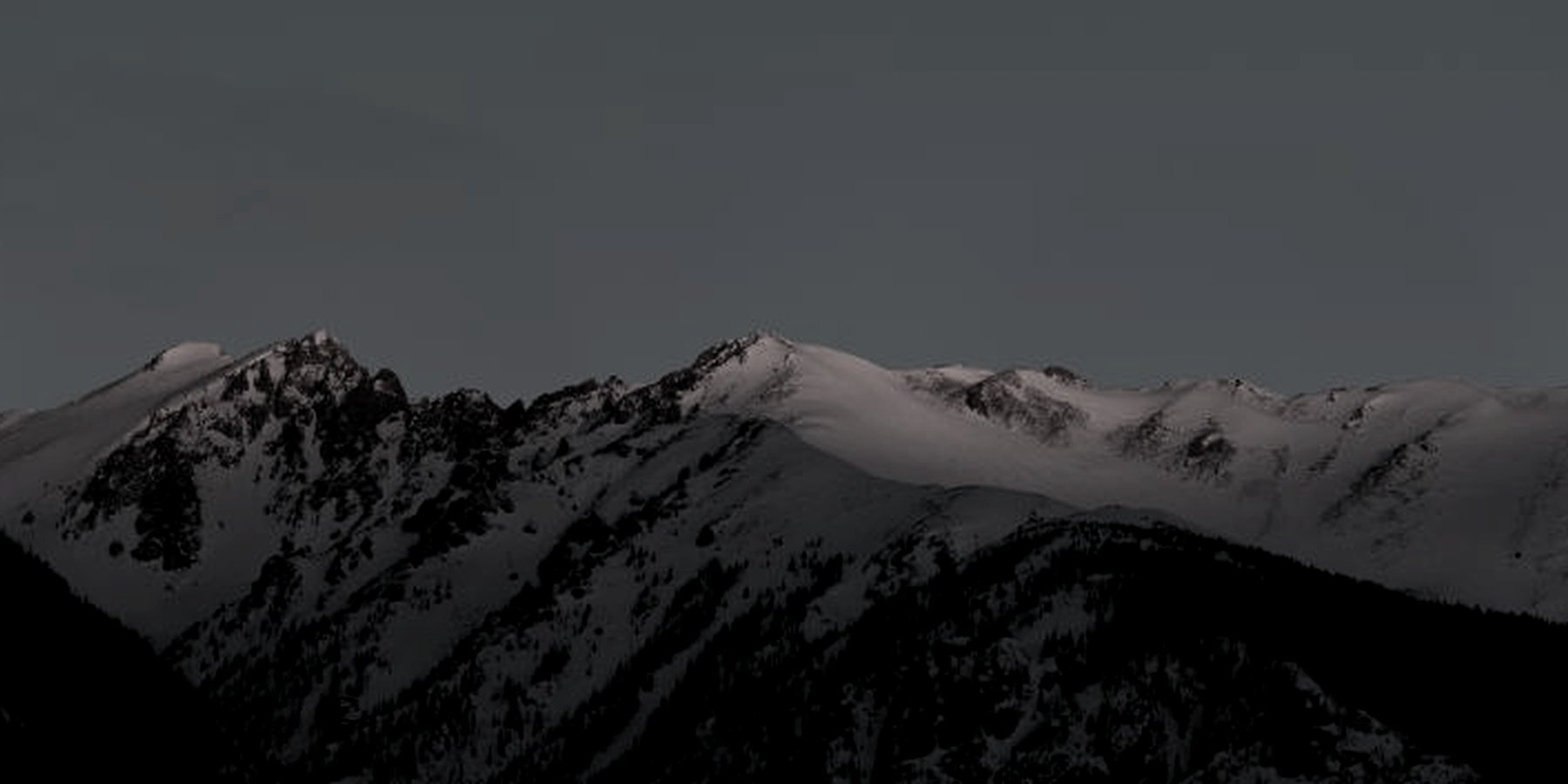 Jagged alpine peaks above an untouched powder field